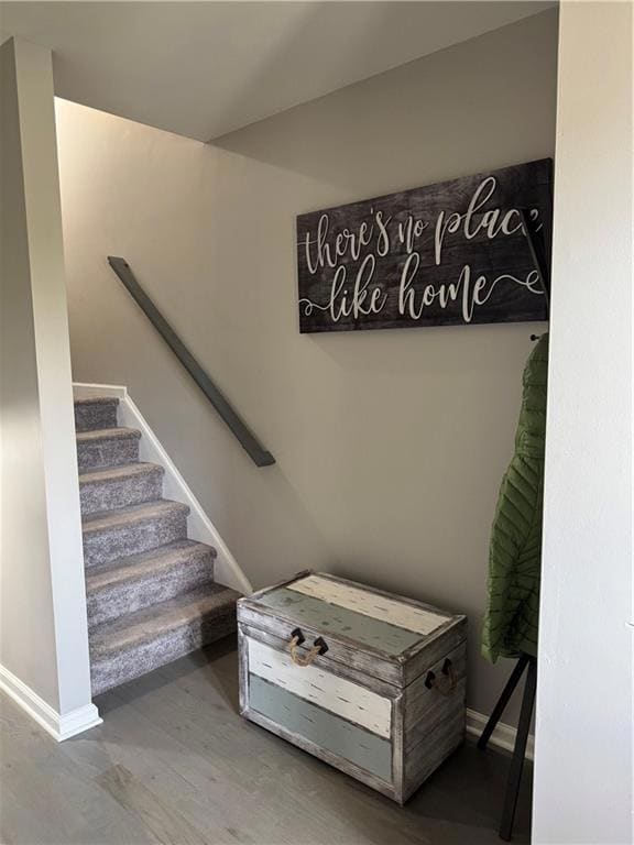 Stairs with wood finished floors and baseboards