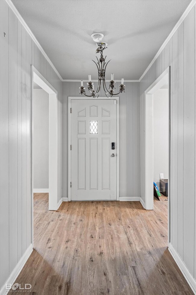 Entryway with a notable chandelier, crown molding,