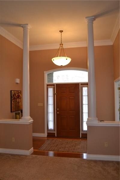 Dramatic column entry with high ceilings, hardwood