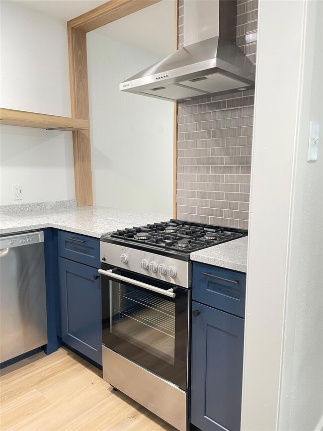 Kitchen featuring stainless steel appliances, wal