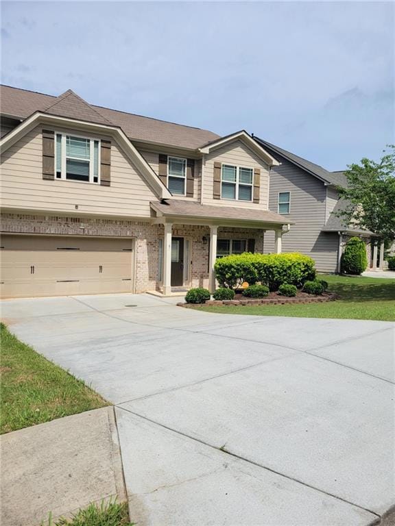 View of front of house with a garage, concrete driveway, brick siding, a shingled roof, and a porch