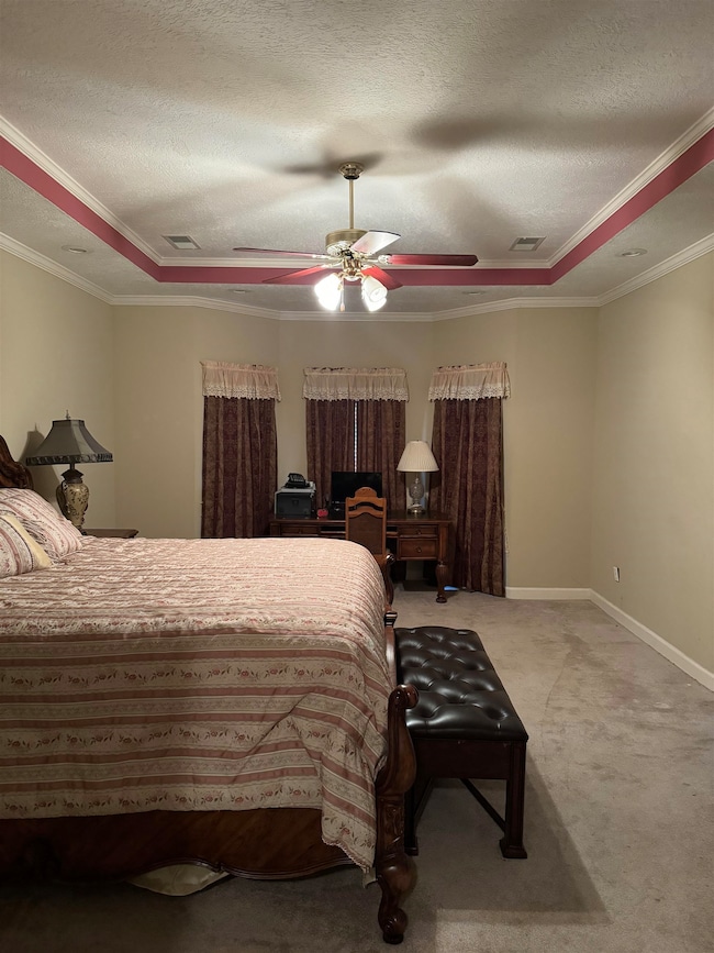 Carpeted bedroom featuring a textured ceiling, cro