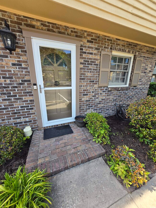 Property entrance featuring brick siding