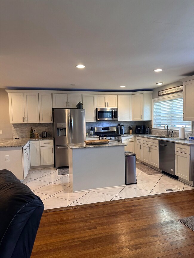 Kitchen featuring light stone counters, a sink, st