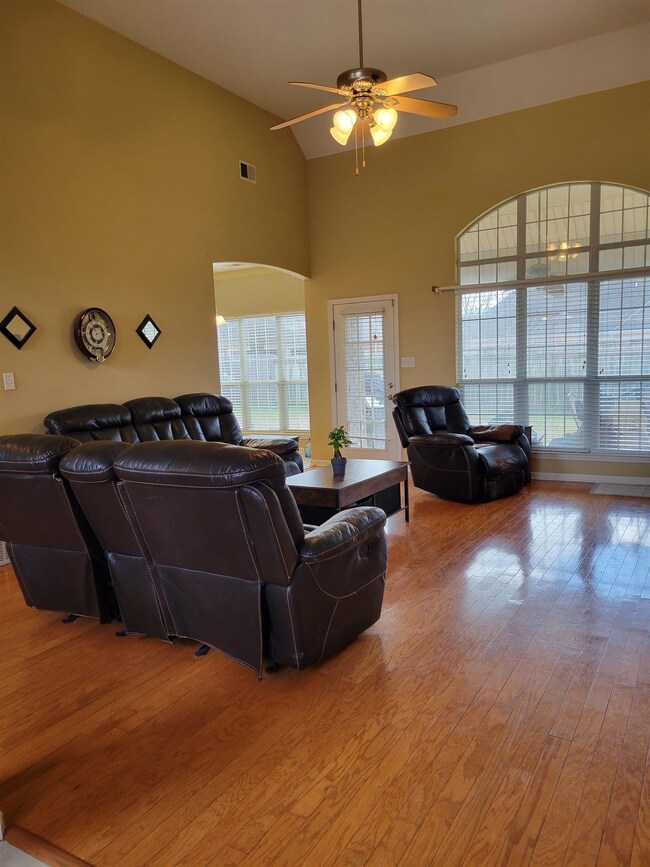Living room featuring high vaulted ceiling, light 