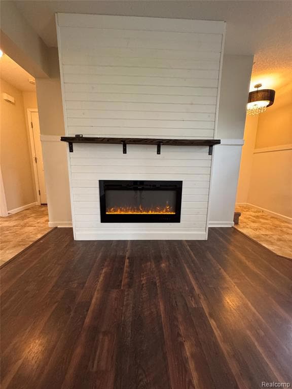 Detailed view of wood finished floors and a large fireplace
