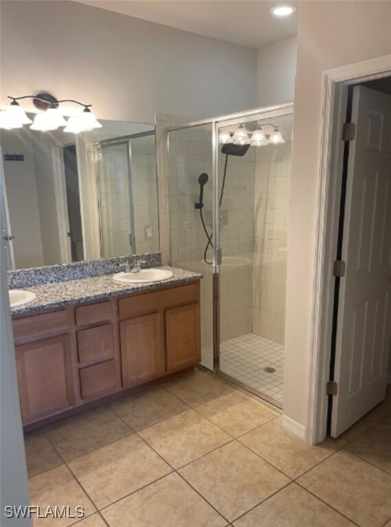 Bathroom featuring tile patterned floors, an enclosed shower, and vanity