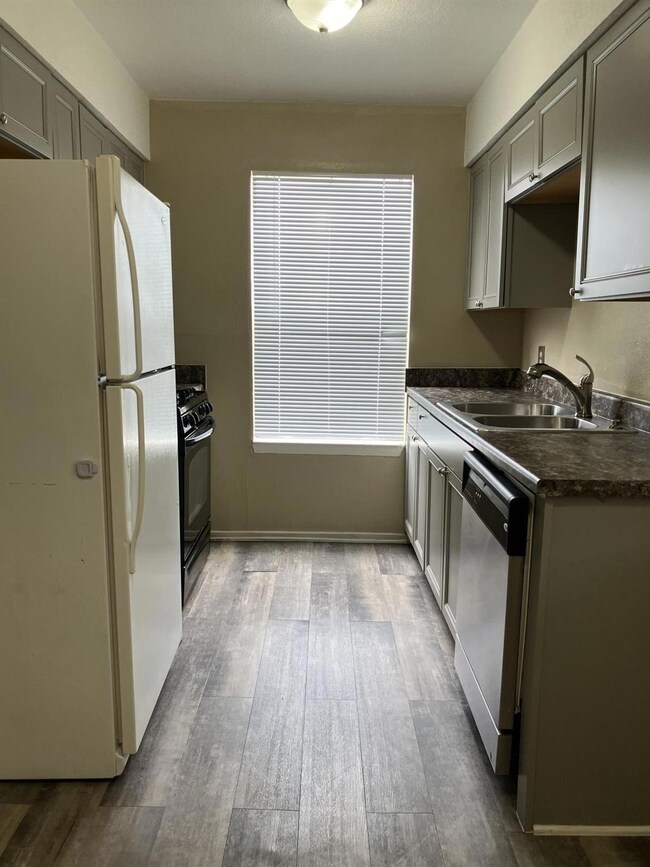 Kitchen featuring a sink, dark countertops, frees
