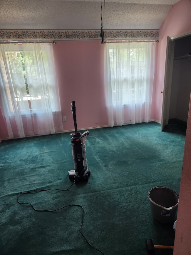 Unfurnished living room with a textured ceiling and carpet floors