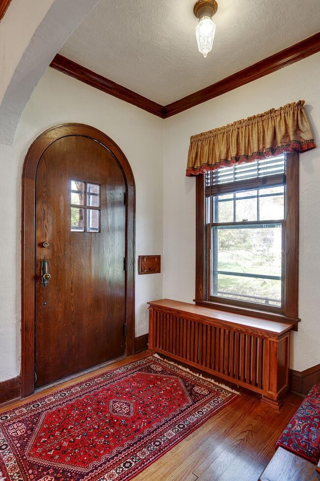 A covered entry with an arched front door provides