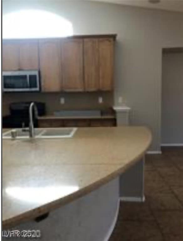 Kitchen with stainless steel microwave, stove, lig