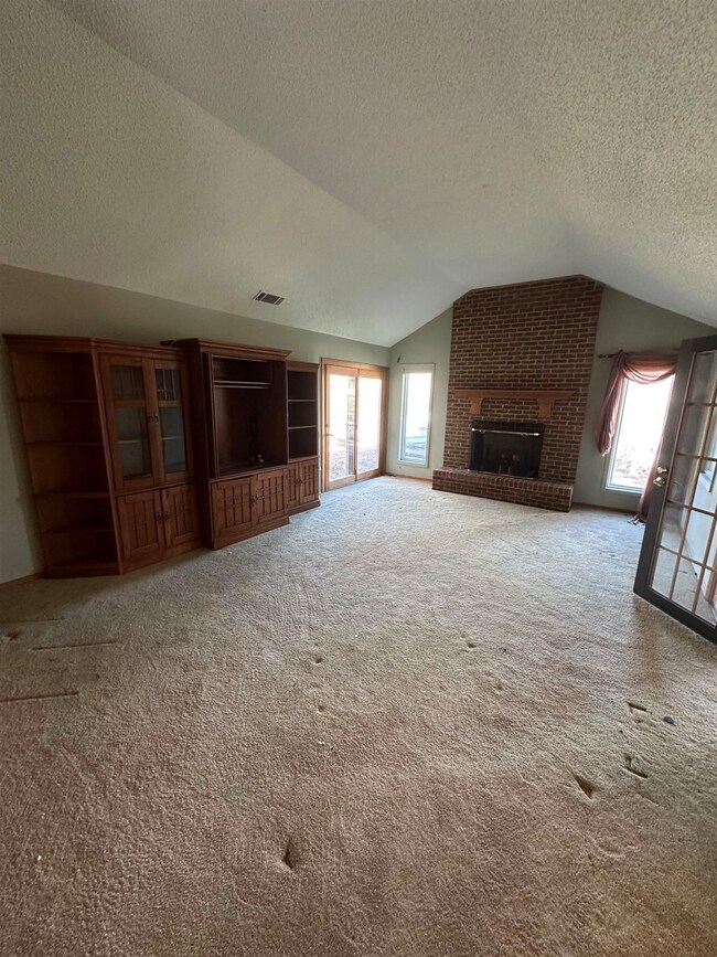 Unfurnished living room featuring carpet floors, l