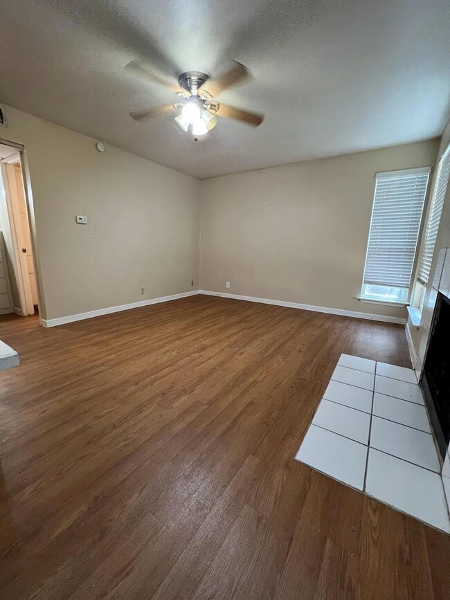Empty room featuring baseboards, a ceiling fan, w