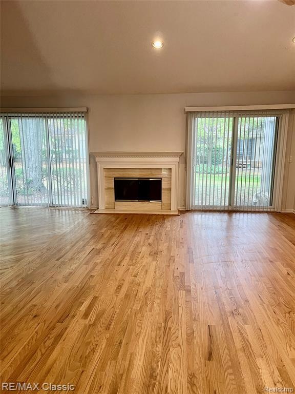 Living room featuring a  fireplace, recessed new hardwood floors