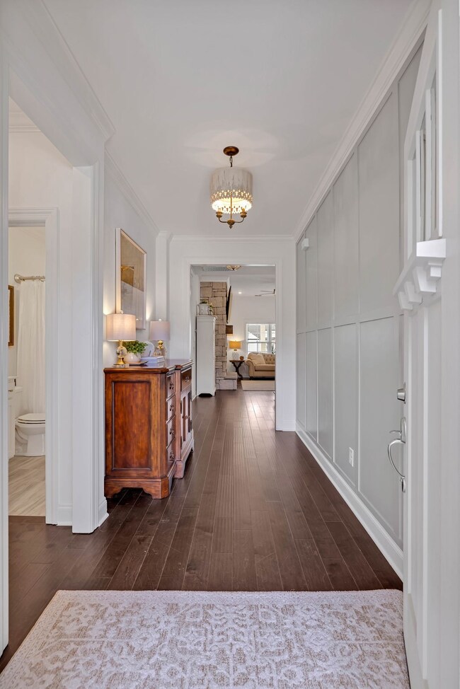 A welcome sight...you'll love this stunning foyer/entryway with beautiful engineered hardwood flooring, updated entry light fixture, crown molding and painted board/batten accent wall!