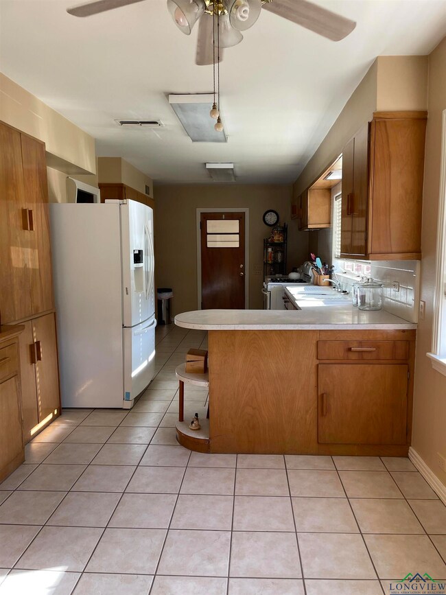 Kitchen featuring brown cabinetry, a peninsula, wh