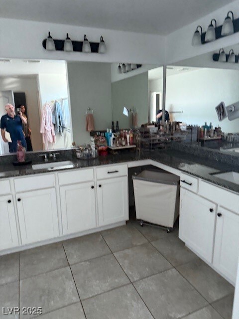 Kitchen featuring a sink, white cabinetry, dishwas