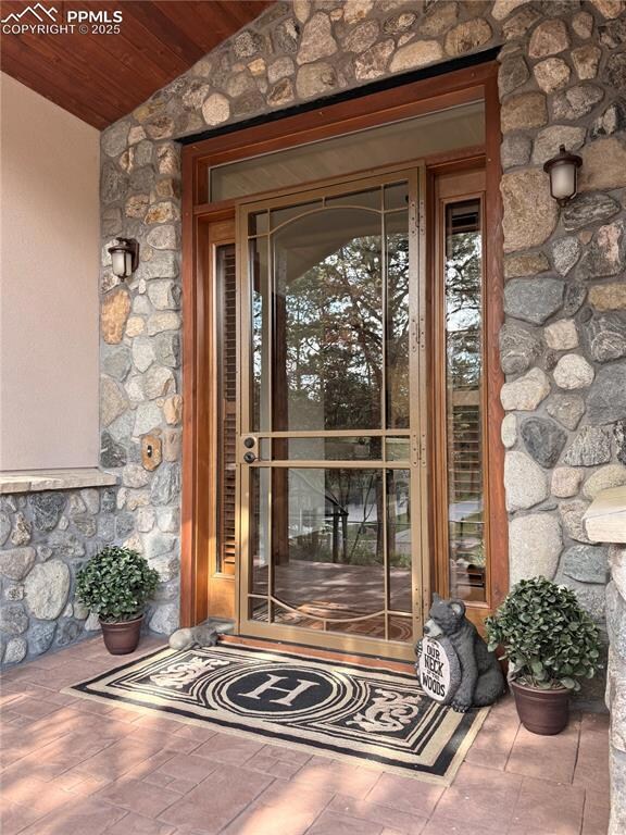 View of exterior entry featuring stone siding