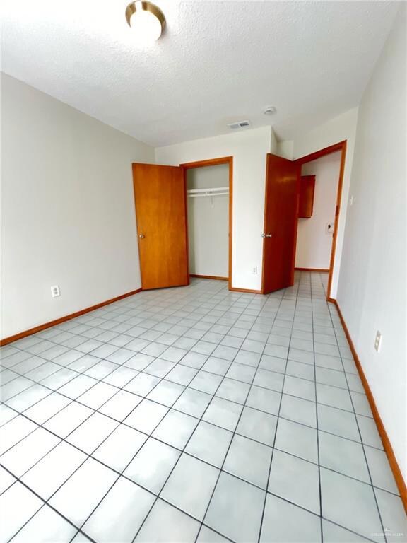 Unfurnished bedroom with a textured ceiling and a closet