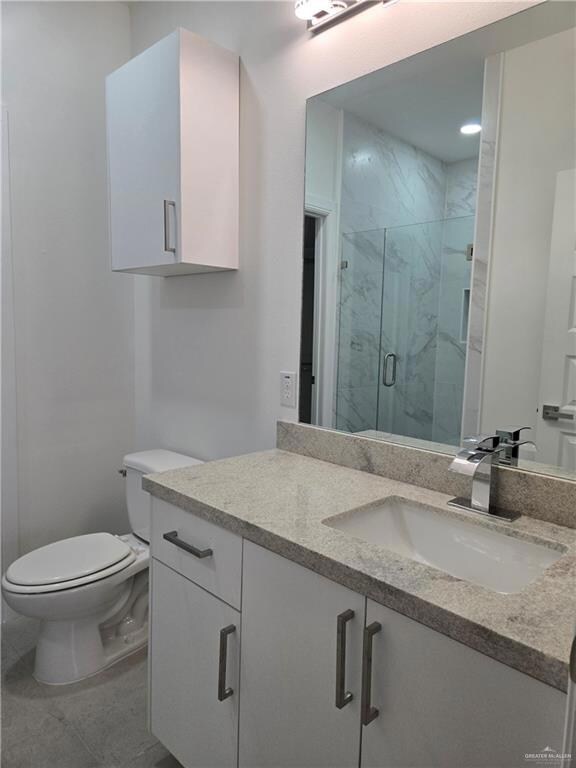 Bathroom with vanity and a marble finish shower