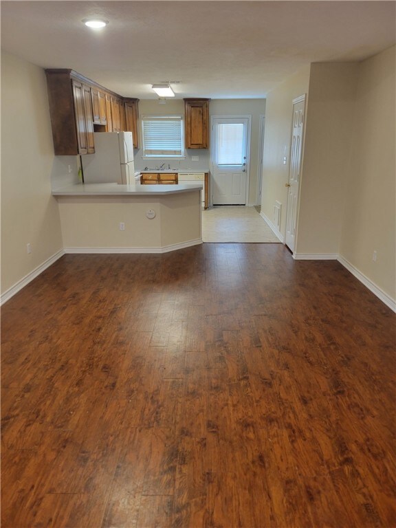 Kitchen with light countertops, baseboards, dark w