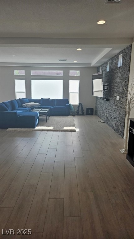 Unfurnished living room featuring wood finished fl