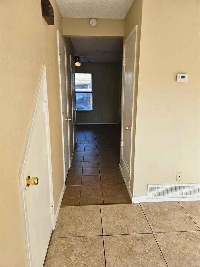 Corridor featuring tile patterned floors and a tex
