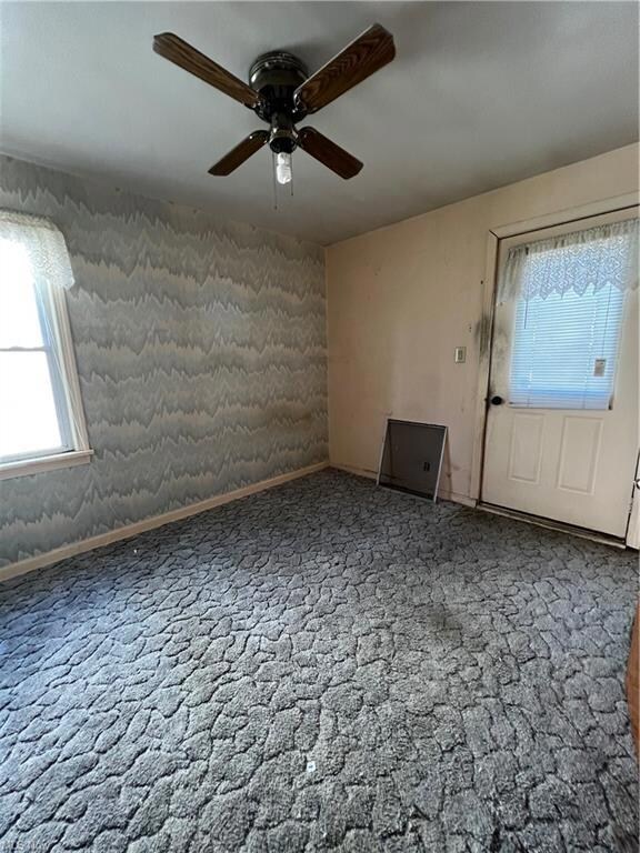 Empty room with carpet and ceiling fan
