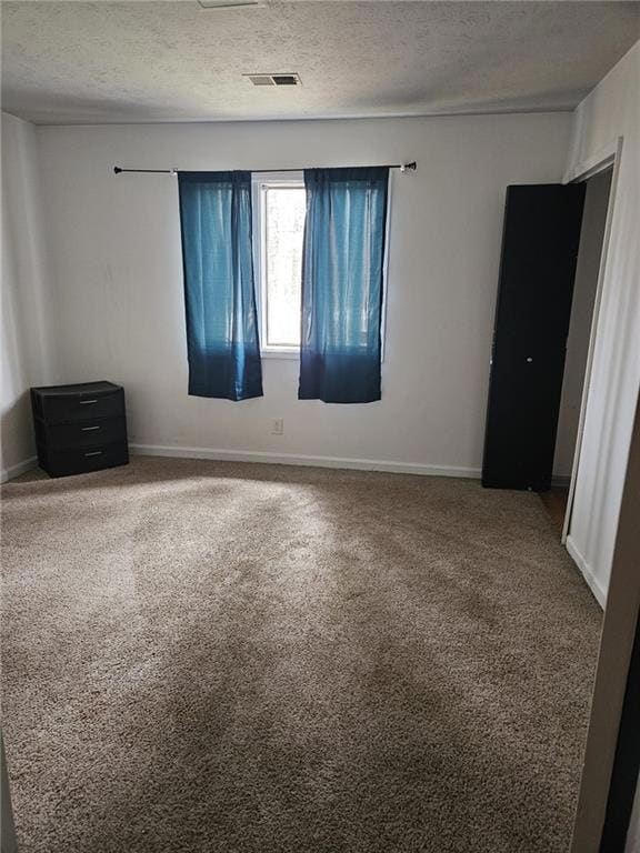 Spare room with carpet floors and a textured ceiling