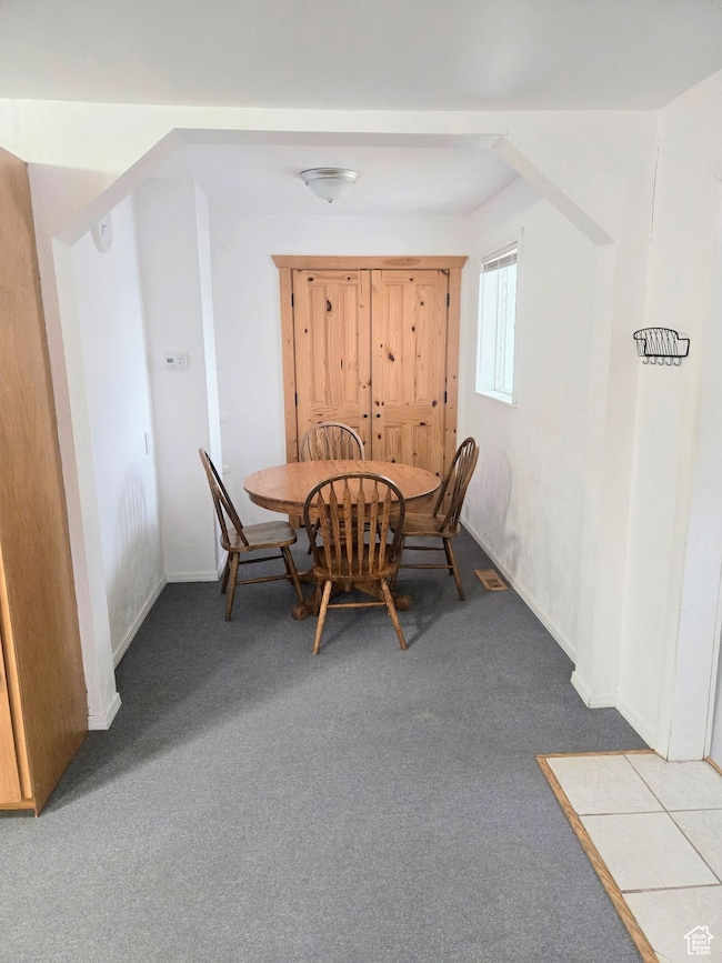Dining room with carpet and arched walkways