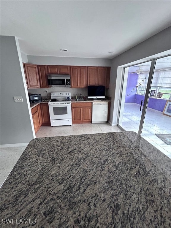 Kitchen with white appliances, ceiling fan, and si