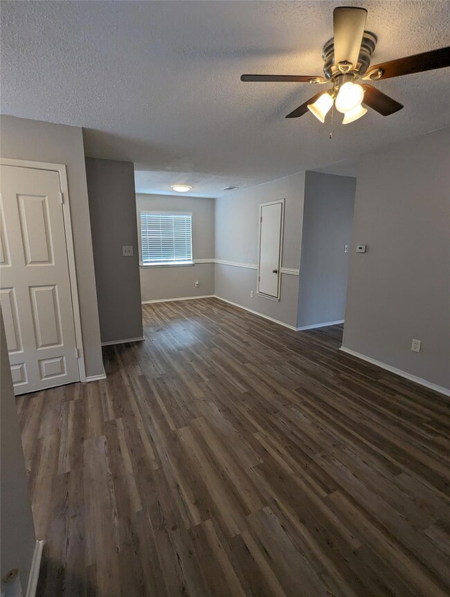 Empty room featuring a textured ceiling, dark woo