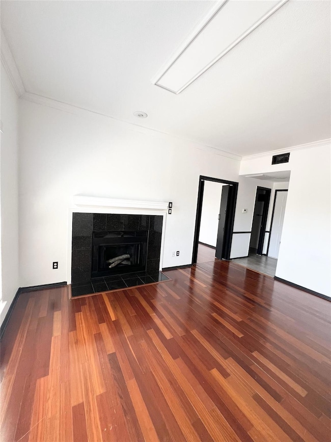 living room with a tile fireplace, visible vents, 