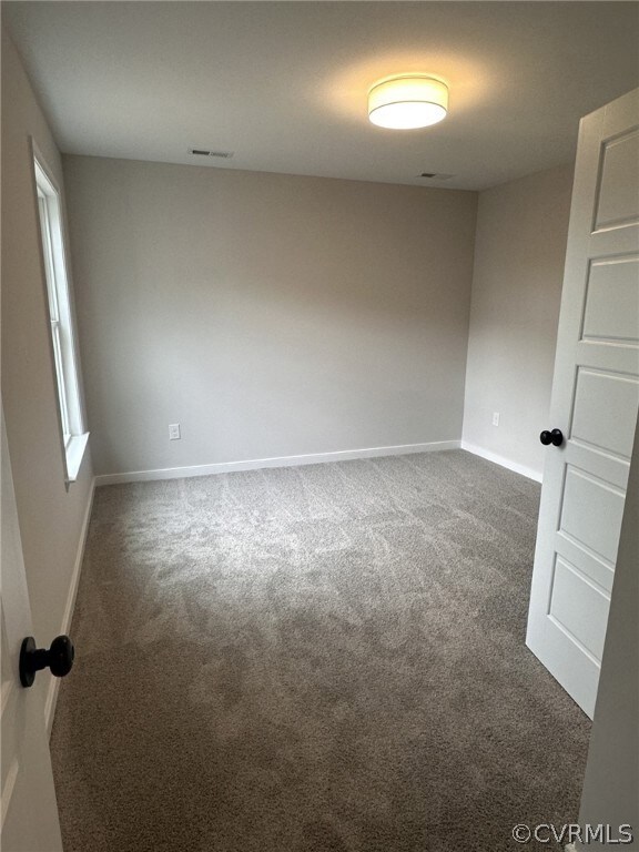 Unfurnished room with dark carpet