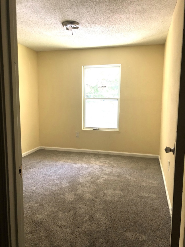 Carpeted empty room featuring a textured ceiling