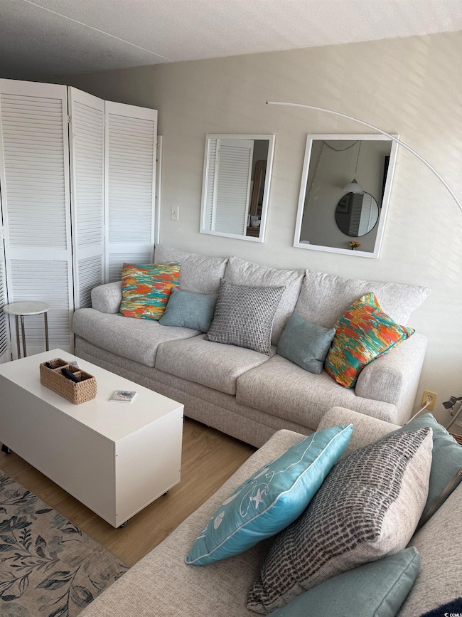 Living area with wood finished floors and a textured ceiling
