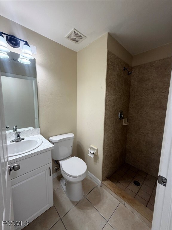 Full bath featuring a shower stall, light tile patterned floors, and vanity