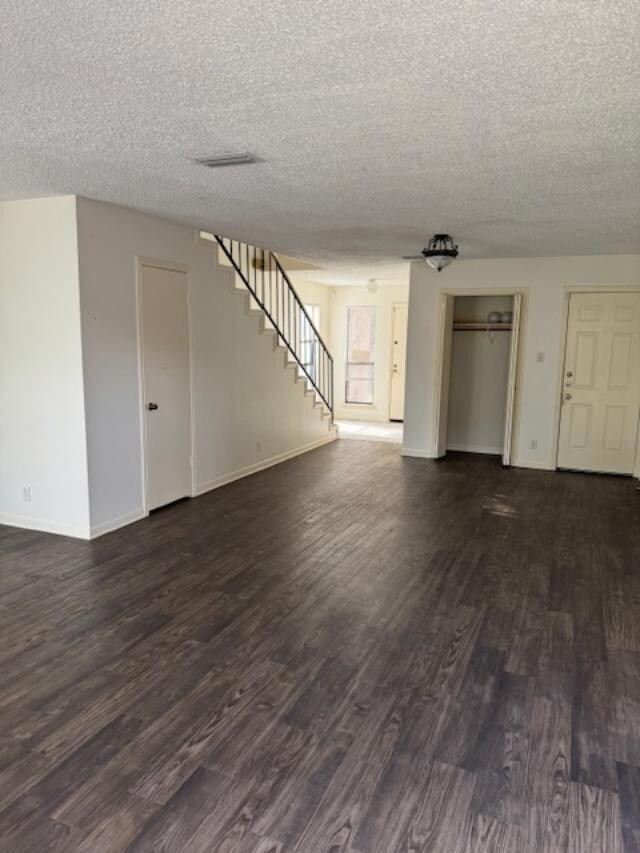 Unfurnished living room with baseboards, a textur