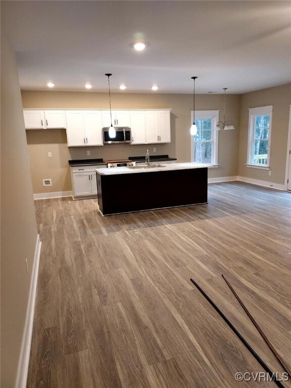 Kitchen with white cabinetry, pendant lighting, an