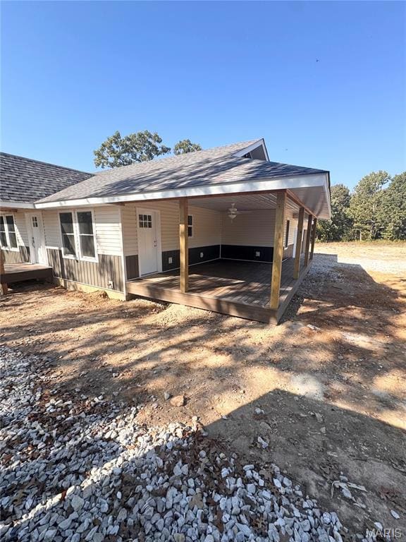 Back of house with roof with shingles and covered porch