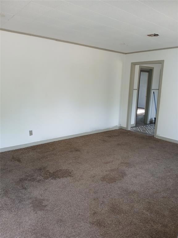 Spare room featuring carpet and baseboards
