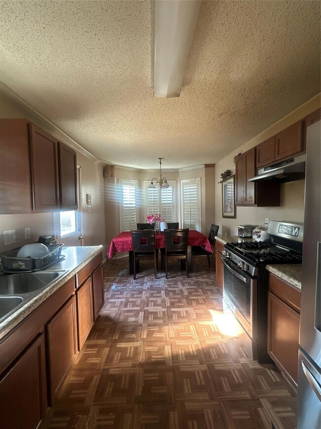 Kitchen featuring a notable chandelier, a textured
