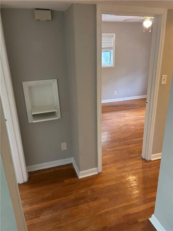 Hall featuring wood-type flooring and baseboards