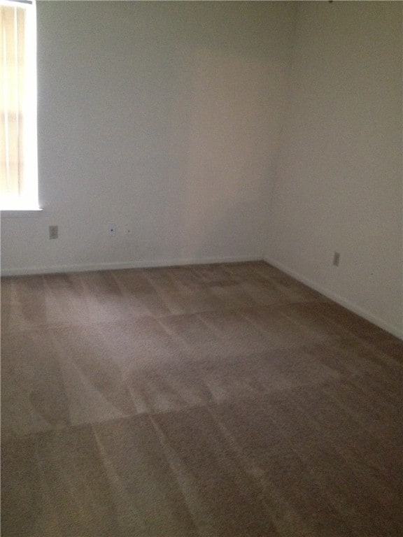 Carpeted spare room with baseboards