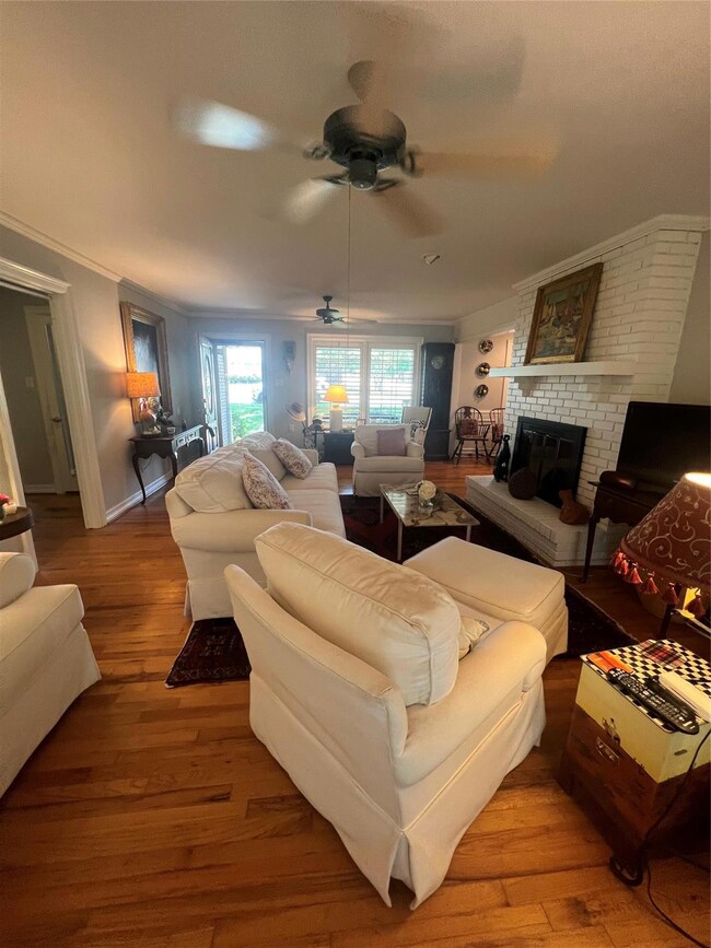Living room featuring ornamental molding, a brick 