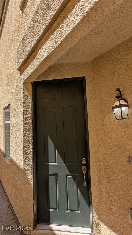 View of exterior entry with stucco siding