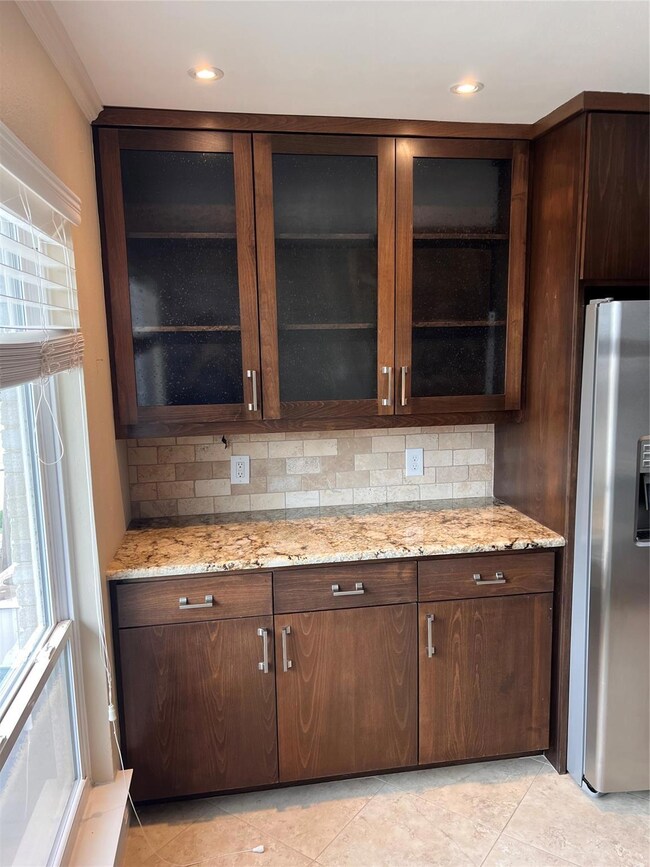 Kitchen featuring light tile floors, light stone c