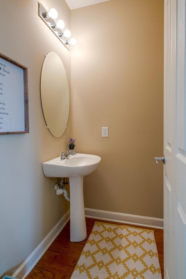 Just across from the Staircase is the Half Bath with a Pedestal Sink and Hardwood Floors!