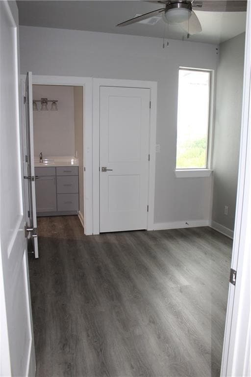 Unfurnished bedroom featuring dark wood-style flo