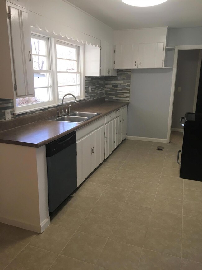 Kitchen area with Tile flooring and new appliances 